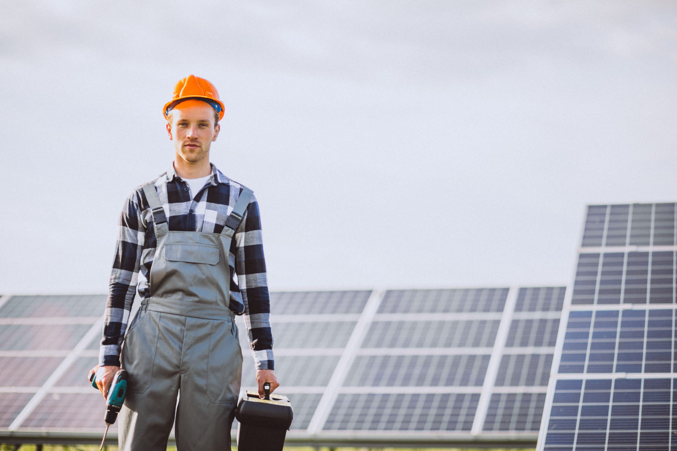 Man worker in the firld by the solar panels